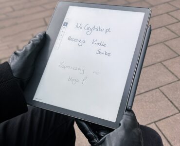 Kindle Scribe na zewnątrz. Na czytniku wyświetla się napis naczytniku.pl