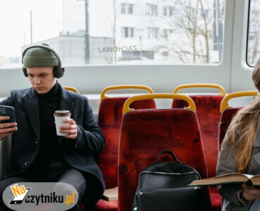 Kobieta czytająca książkę i mężczyzna korzystający z telefonu podczas jazdy komunikacją miejską. Mały czytnik e-booków pozwala mężczyźnie cieszyć się lekturą nawet podczas krótkiej podróży.